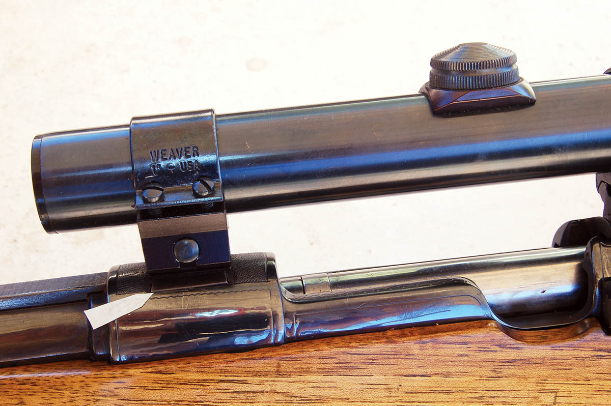 Filler for the claw-mount base can just be seen peeking out from under the Weaver base (arrow). All markings were removed from military action. Note the thumb cut.